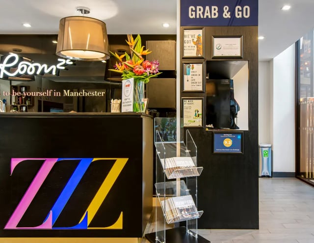Reception desk with ZZZ logo and floral arrangement lobby at Manchester Victoria in Manchester Student Accommodation