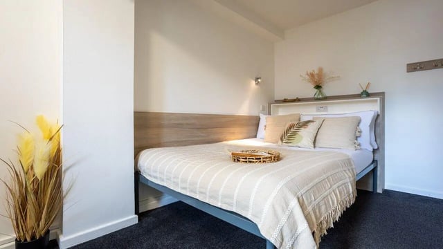 Bed with pillows and plant bedroom at Manchester Student Village in Manchester Student Accommodation