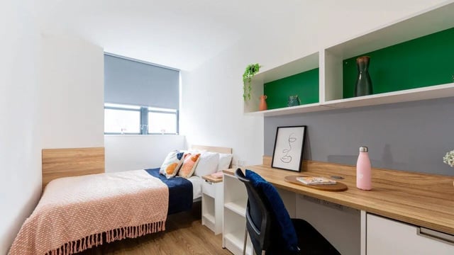 Bed desk shelves with pink water bottle Bedroom at Manchester Student Village in Manchester Student Accommodation