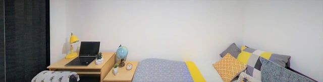 Desk with laptop globe lamp bed and pillows bedroom at The Grafton in Manchester Student Accommodation