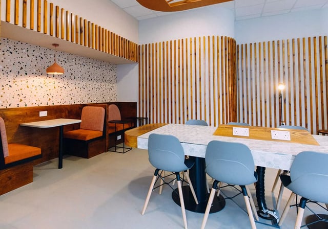 Modern study area with tables chairs and booths. at iQ Exchange in Nottingham Student Accommodation