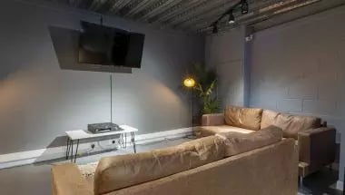 Lounge area with sectional sofa turntable TV living room at iQ Broderick House in Birmingham Student Accommodation