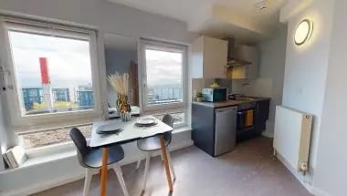 Table chairs kitchen counter living room at iQ Broderick House in Birmingham Student Accommodation