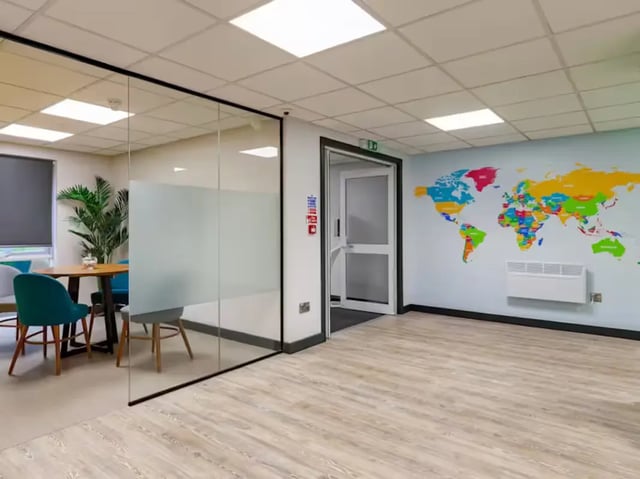 Glass room with table chairs and world map common area at Foundry Court in Preston Student Accommodation
