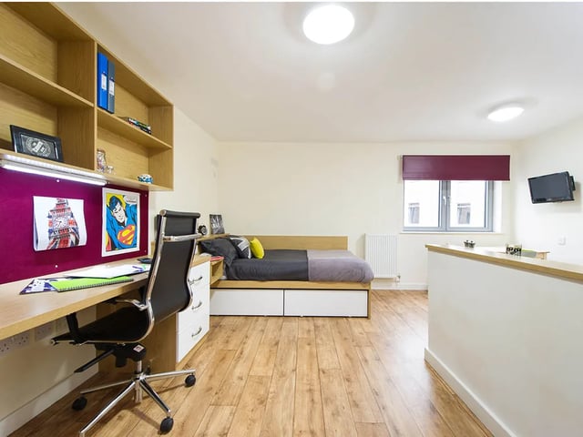 Desk bed shelves chair with Superman art bedroom at Quebec House in Kingston Upon Thames Student Accommodation