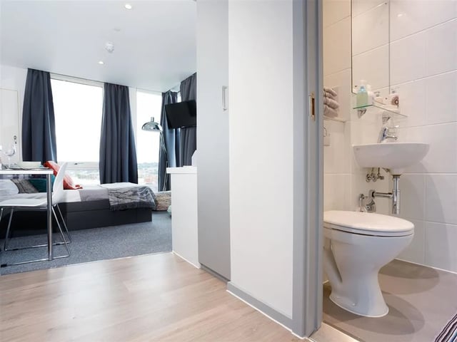 Bed TV desk chair and bathroom Bathroom at Queen Street Studios in Exeter Student Accommodation