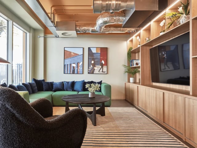 Green sectional sofa with dark cushions living room at Queen Street Studios in Exeter Student Accommodation