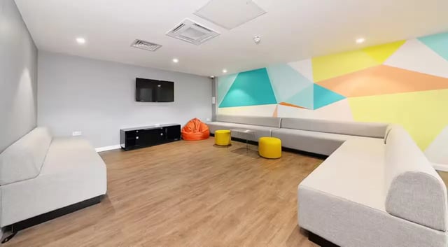 Sofas TV console orange beanbag yellow ottomans living room at The Mill House in Edinburgh Student Accommodation