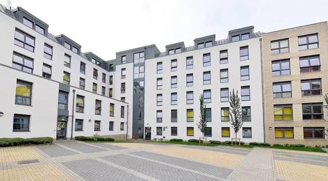 Modern apartment buildings with numerous windows and courtyard exterior. at The Mill House in Edinburgh Student Accommodation