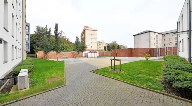 Paved courtyard with benches and trees exterior at The Mill House in Edinburgh Student Accommodation