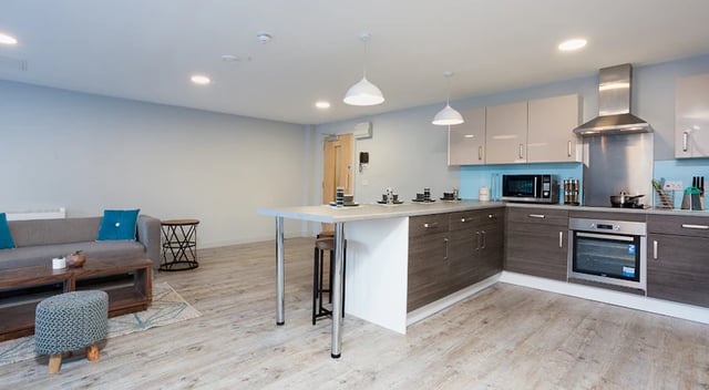 Sofa island kitchen cabinets oven microwave living room kitchen at The Tramshed in Preston Student Accommodation
