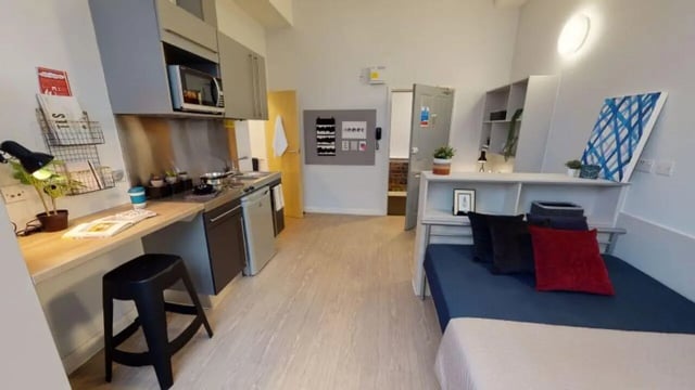 Bed kitchen area with appliances and desk bedroom Image at iQ Studios 51 in Birmingham Student Accommodation