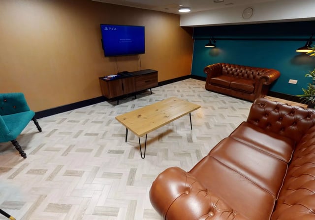Brown sofas TV and wooden coffee table living room at iQ Studios 51 in Birmingham Student Accommodation
