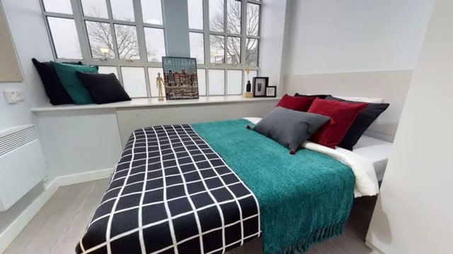 Bed with pillows and artwork bedroom at iQ Studios 51 in Birmingham Student Accommodation