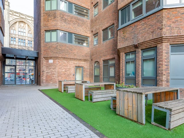 Wooden picnic tables on grass exterior at The Fitzalan in Cardiff Student Accommodation