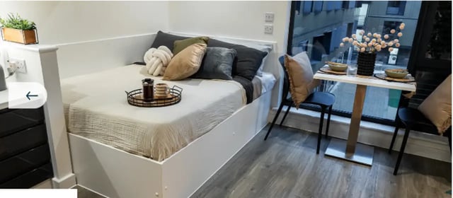 Bed with tray and small table with chairs bedroom at Palamon Court in Canterbury Student Accommodation