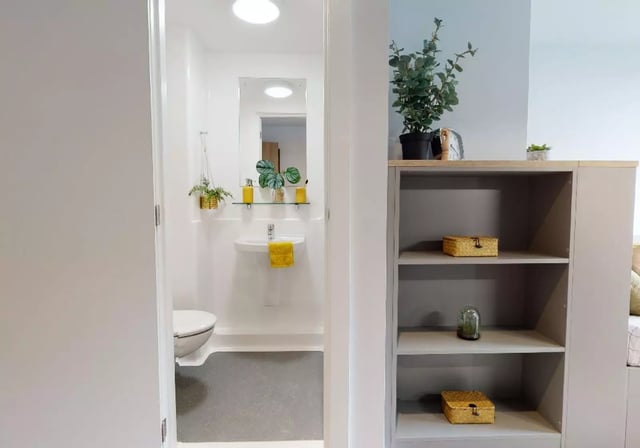 Toilet sink mirror yellow towel shelving storage bathroom at iQ Altus House in Leeds Student Accommodation