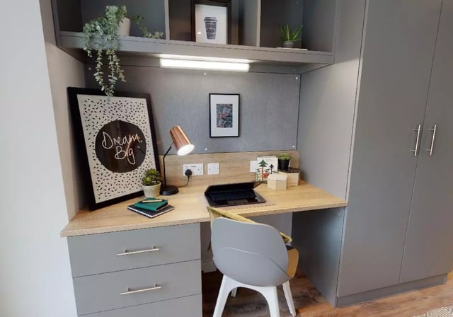 Desk with laptop chair and framed art Study area at iQ Altus House in Leeds Student Accommodation