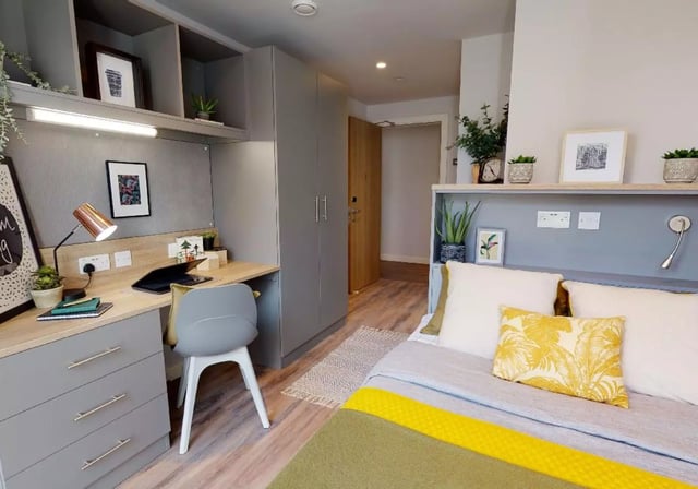 Desk plants lamp and bed in room Bedroom at iQ Altus House in Leeds Student Accommodation