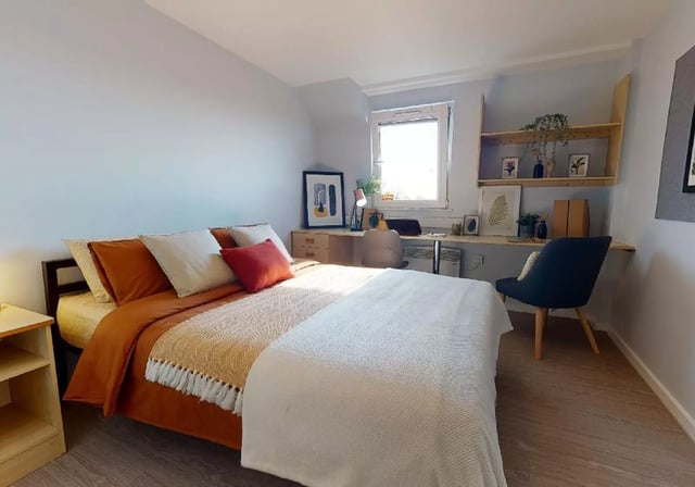 Bed with pillows desk chair and shelving bedroom at Opal Court Leicester in Leicester Student Accommodation