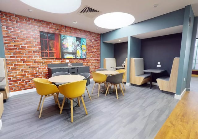 Round tables yellow chairs booth seating communal area at iQ Will Wyatt Court in London Student Accommodation