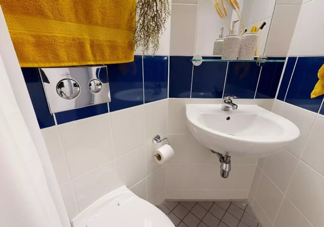 Toilet sink and yellow towel bathroom at iQ Will Wyatt Court in London Student Accommodation