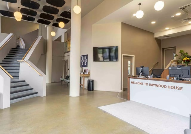 Reception desk and stairwell with modern lighting Lobby at iQ Haywood House in London Student Accommodation