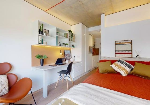 Desk laptop chair shelving bed with pillows living room at iQ Flinders House in London Student Accommodation