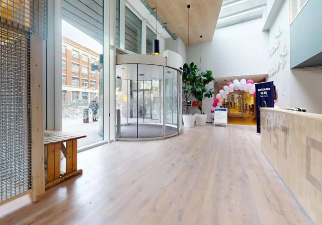 Reception area with revolving door and plants at iQ East Court in London Student Accommodation
