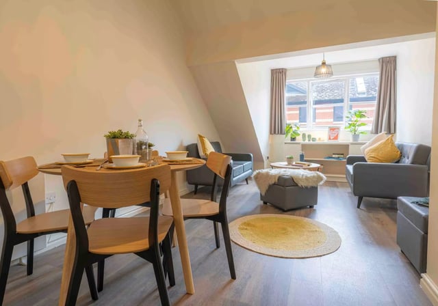 Dining table and chairs with living room furniture living area at iQ Fletcher House in Manchester Student Accommodation