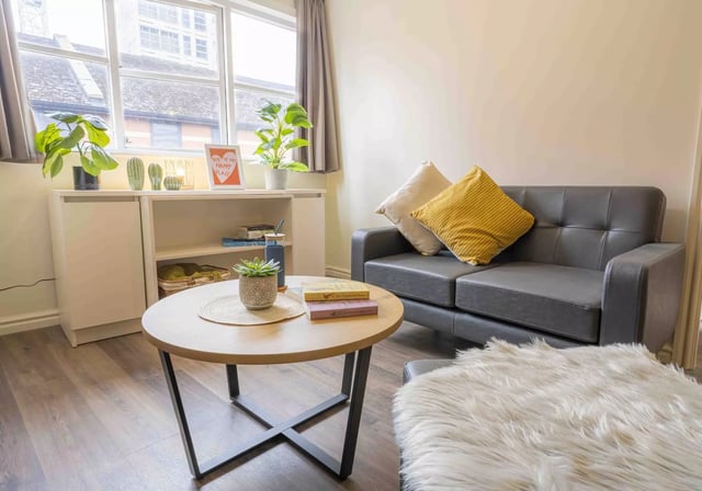 Sofa coffee table plants and shelving living room at iQ Hollingworth House in Manchester Student Accommodation