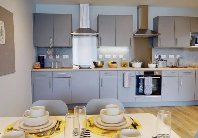 Gray cabinets oven dining table kitchen at iQ Nelson Court in Nottingham Student Accommodation
