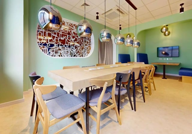Dining table and chairs with modern light fixtures common area at iQ Nelson Court in Nottingham Student Accommodation
