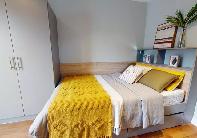 Wardrobe bed with yellow throw and pillows bedroom at iQ Knight House in Sheffield Student Accommodation