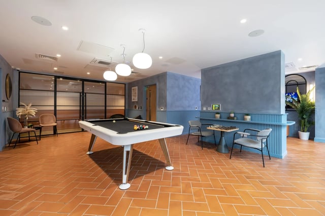 Pool table chairs chessboard and plant living room at Aster House in Belfast Student Accommodation
