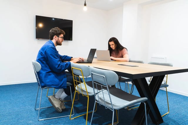 Students working laptops at communal table study area at Altura Birmingham in Birmingham Student Accommodation