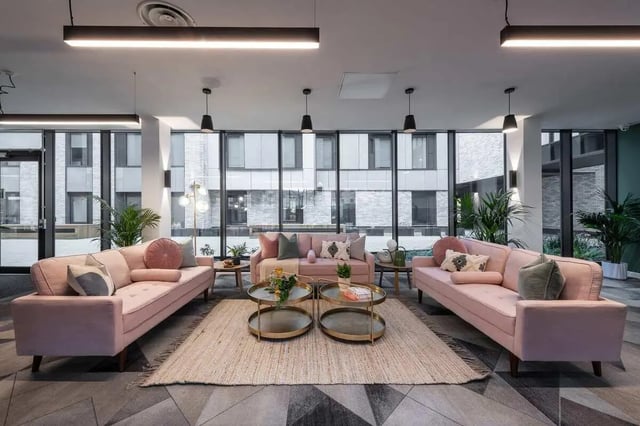 Three pink sofas with coffee tables and plants living room at Infinity Coventry in Coventry Student Accommodation