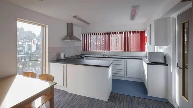 Kitchen with white counters cupboards microwave kettle kitchen at Treliske Key Workers in Truro Student Accommodation