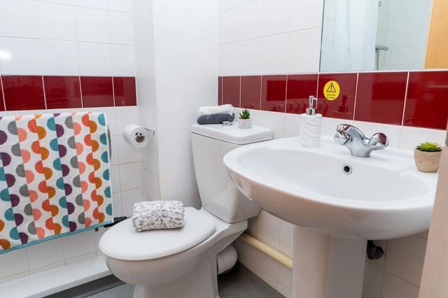 Toilet sink towels soap dispenser plant bathroom at Wardley House Key Workers in Bradford Student Accommodation