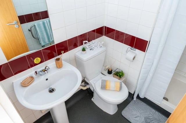 Sink toilet towel and shower curtain bathroom at Wardley House Key Workers in Bradford Student Accommodation