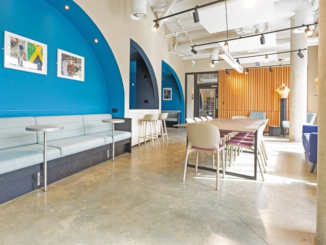 Blue booth seating tables chairs and wooden wall communal area at The Terry Frost Building in Leeds Student Accommodation