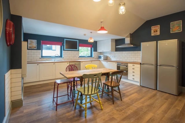 Table chairs refrigerators counter and sink kitchen at Mary Morris House in Leeds Student Accommodation