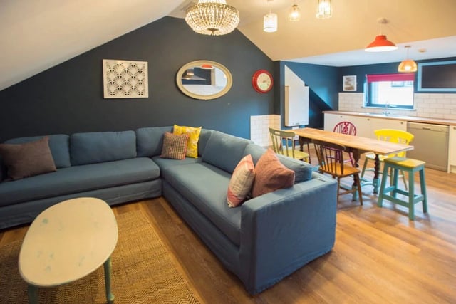Blue sectional sofa kitchen table chairs living area at Mary Morris House in Leeds Student Accommodation