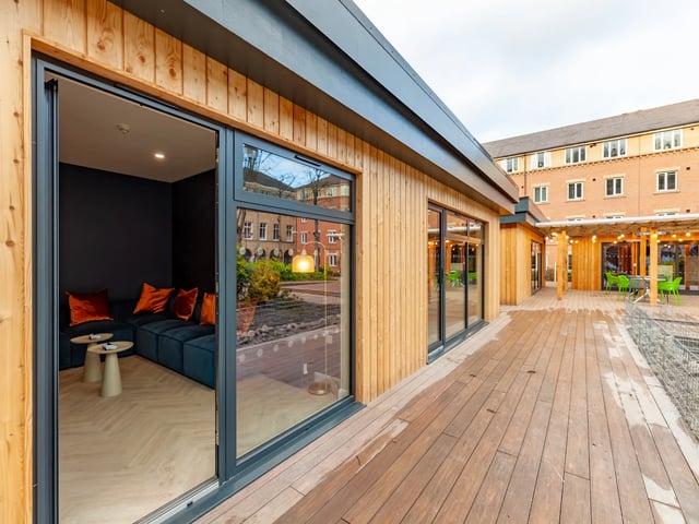 Sectional couch with orange cushions outdoor seating area at The Leather Works in Leeds Student Accommodation