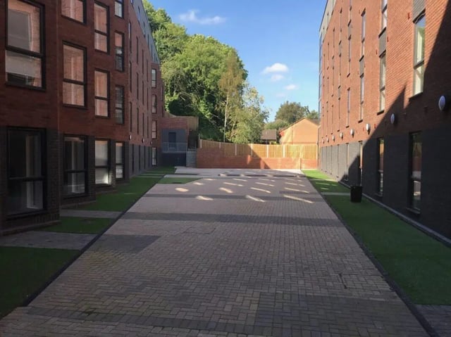 Brick buildings green grass paved courtyard exterior at Q Studios in Stoke-On-Trent Student Accommodation