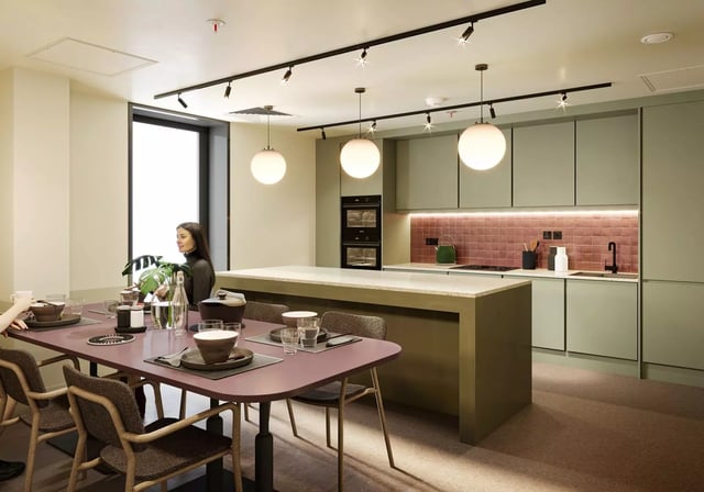 Dining table with place settings and kitchen island kitchen at Longwood Place in Coventry Student Accommodation