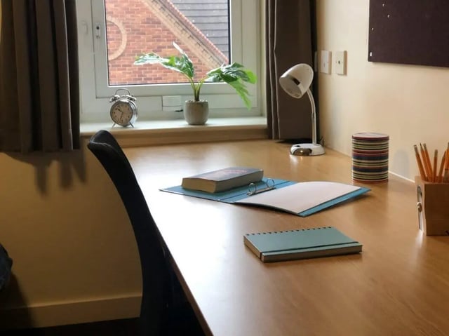 Desk with lamp books chair and plants study area at Foundry 1 in Loughborough Student Accommodation