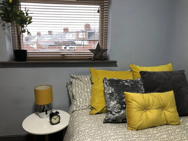 Bed with yellow pillows and alarm clock Bedroom at Millfield House in Sunderland Student Accommodation