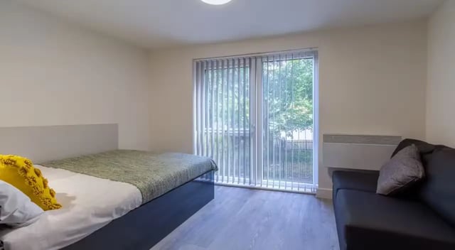 Bed sofa and window student studio bedroom at Dover Street Apartments in Leicester Student Accommodation