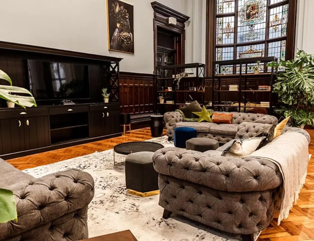 Chesterfield sofas bookshelves TV and stained glass Living room at John Bell House in Belfast Student Accommodation